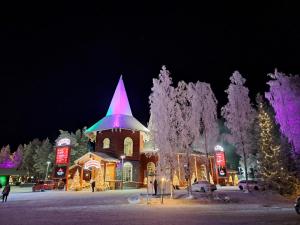 a church with a christmas lights on it at night at Room in Polar Circle in Rovaniemi