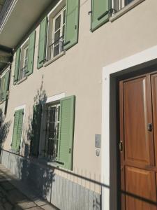 ein Gebäude mit grünen Rollläden und einer Tür in der Unterkunft Casa Rocca in Roccaforte Mondovì
