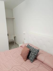 a bedroom with a pink bed with two pillows at Villa Ada in Santa Domenica