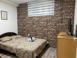 una camera da letto con un letto e un muro di mattoni di Apartman Urosevic a Jagodina
