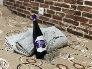una bottiglia di vino seduta su un tavolo con un bicchiere di Apartman Urosevic a Jagodina