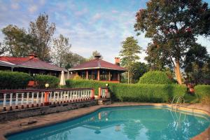 a house with a swimming pool in front of a house at Kluges Guest Farm in Kibale