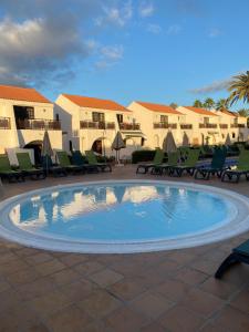 een zwembad met stoelen en een resort bij Parquemar in Playa del Inglés