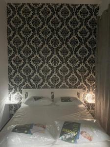 ナポリにあるcasa paganoのベッドルーム1室(ベッド1台付)が備わります。壁紙を用いた内装です。