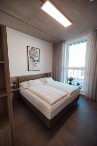 a bedroom with a large bed and a window at City Rooms Amstetten in Amstetten