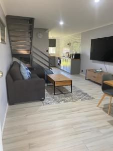a living room with a couch and a flat screen tv at Kalbarri Reef Villa 3 in Kalbarri