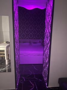 ナポリにあるcasa paganoの紫色のカーテン付きの紫色のベッド1台