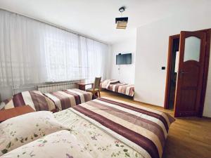 a hotel room with three beds and a window at Pokoje Gościnne Letycja in Biały Dunajec