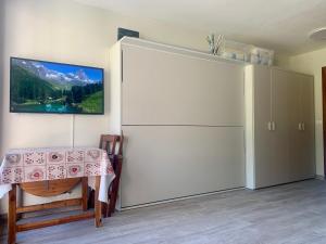 einen großen weißen Kühlschrank in einem Zimmer mit einem Tisch in der Unterkunft Cervinia Ski In Ski Out - Studio with Terrace in Breuil-Cervinia