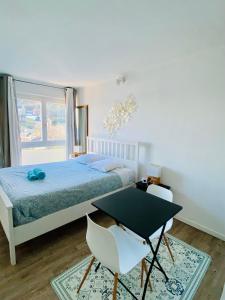 1 dormitorio con 1 cama, mesa y sillas en Appartement N°8 Vue Mer, Perros Guirec, en Perros-Guirec