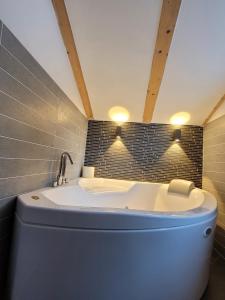 uma banheira na casa de banho com um lavatório em Relax in Pineta em Caldonazzo