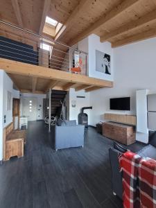 a living room with wooden ceilings and a staircase at Relax in Pineta in Caldonazzo