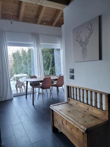 uma sala de jantar com mesa e cadeiras e um banco em Relax in Pineta em Caldonazzo