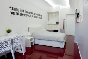 a small bedroom with a white bed and a desk at Il Castelluccio in Arezzo