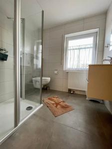 een badkamer met een douche en een wastafel bij Ferienhaus Seehund in Krummhörn