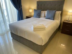 um quarto com uma cama grande e almofadas azuis em Studio Apartment - Royal Breeze 05 em Ras al-Khaimah