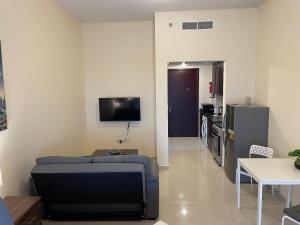 a living room with a couch and a flat screen tv at Studio Apartment - Royal Breeze 05 in Ras al Khaimah