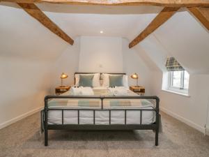 een slaapkamer met een bed op zolder bij Thomas Cottage in Wotton under Edge