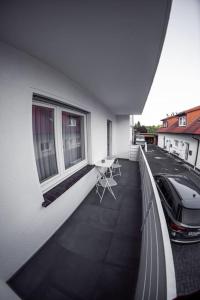 un balcón con un coche aparcado en el lateral de un edificio en Wunderschöne neue 3,5 Zimmerwohnung Nähe Kassel bis 4 Erwachsene 3 Kinder en Fuldatal