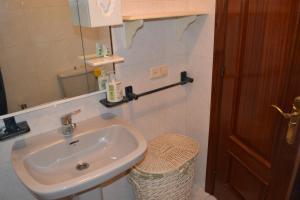 baño con lavabo y espejo en la pared en Coqueto Duplex en Vilagarcía de Arousa centro, en Vilagarcía de Arousa