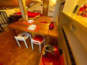 Una pequeña cocina con una mesa y sillas y una habitación. en Matrioska House B&B, en Imola