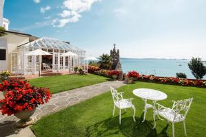 a patio with a table and chairs and the ocean at Panorama Guest House in Saint Aubin