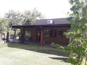 een klein huis met een veranda en een tuin bij Sueño Bonito in San Andrés de Giles