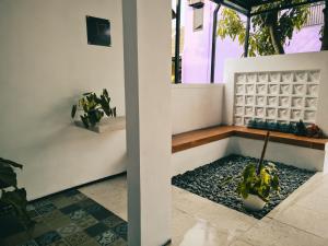 une terrasse couverte avec un banc et une plante en pot dans l'établissement El jenna syariah villas, à Colomadu