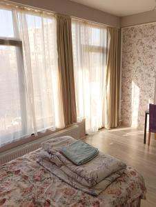 a bedroom with a large bed with a large window at Mary's Cozy & Lovely studio on very quiet Khosharauli street in Tbilisi City