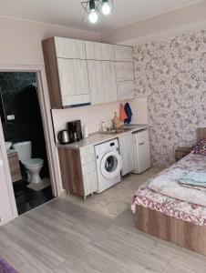 baño pequeño con lavabo y lavadora en Mary's Cozy & Lovely studio on very quiet Khosharauli street, en Tiflis