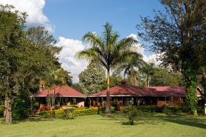 a building with a palm tree in front of it at Kluges Guest Farm in Kibale