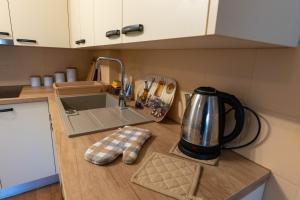 a kitchen counter with a tea kettle and a sink at Studio apartmani "Štimac" in Garešnica