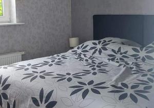 een slaapkamer met een bed met een blauw en wit dekbed bij Vakantiewoning - ‘t Ouwershuys in Opoeteren