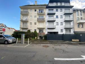 un grand bâtiment avec un parking en face de celui-ci dans l'établissement Naïades 2, à La Baule