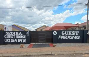 a guest house guest parking sign in front of a house at sediba guest house in Krugersdorp