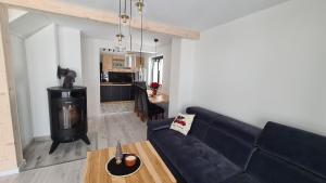 a living room with a blue couch and a table at Domek pod Wiśnią in Mizerna