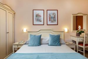 a bedroom with a bed with blue pillows at La Quiete Park Hotel in Manerba del Garda