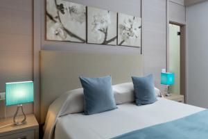 a bedroom with a bed with two blue pillows at La Quiete Park Hotel in Manerba del Garda