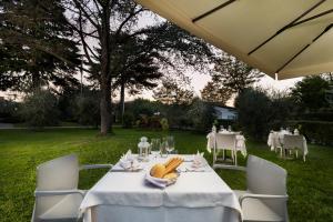 uma mesa com uma toalha de mesa branca e bananas sobre ela em La Quiete Park Hotel em Manerba del Garda