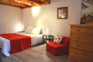 - une chambre avec un lit, une chaise et une commode dans l'établissement Granges 32 - Beau Duplex spacieux, au pied des pistes Domaine Alpe d'Huez, à Villard-Reculas