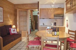 Il comprend une cuisine et un salon avec une table et un canapé. dans l'établissement Granges 32 - Beau Duplex spacieux, au pied des pistes Domaine Alpe d'Huez, à Villard-Reculas