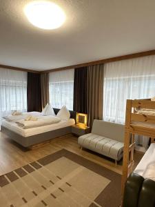 a bedroom with a large bed and a couch at Pension Alpina in Roppen
