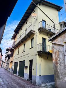 ein gelbes Gebäude mit Balkonen auf einer Straße in der Unterkunft Sotto il tetto in Sagliano Micca