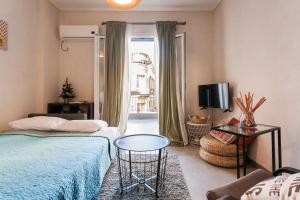 - une chambre avec 2 lits, une table et une télévision dans l'établissement OpenAir HOT TUB/Big Balcony/Great Boutique Apt, à Athènes