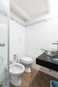 ローマにあるSunny Apartment Navona Squareの白いバスルーム(トイレ、ガラスの洗面台付)