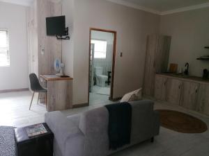 a living room with a couch and a mirror at On Enslin selfcatering in Middelburg
