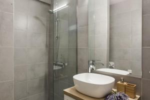 a bathroom with a sink and a glass shower at Amazing new Elegant Apt in the shadow of Acropolis (and Netflix) in Athens