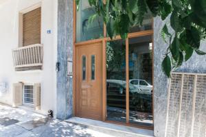 uma porta para um edifício com um carro na janela em Amazing new Elegant Apt in the shadow of Acropolis (and Netflix) em Atenas