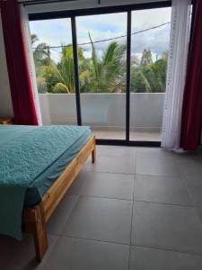 a bedroom with a bed and a large window at MoonLight Residence in Pointe aux Piments +22 photos