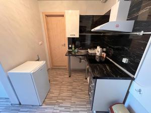 a kitchen with a black counter top and a refrigerator at Studio SeaDream in Primorsko